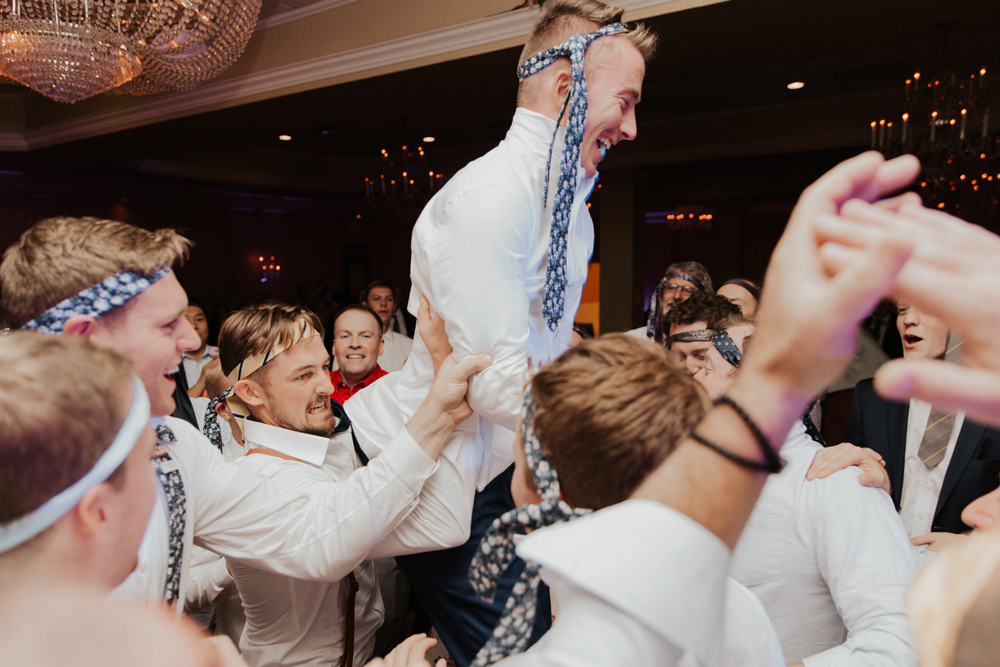 A joyful man is lifted by a crowd at a celebration. A joyful man is lifted by a crowd at a celebration.