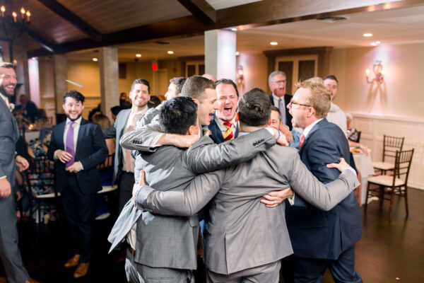 A group of men hugging each other in front of a crowd.