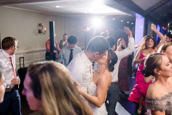 A couple kissing in front of the crowd at an event.