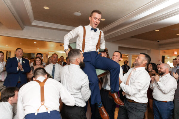 A man is lifted up by some men in suits.