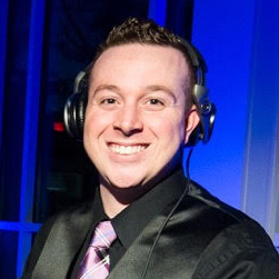 A man wearing headphones and smiling for the camera.