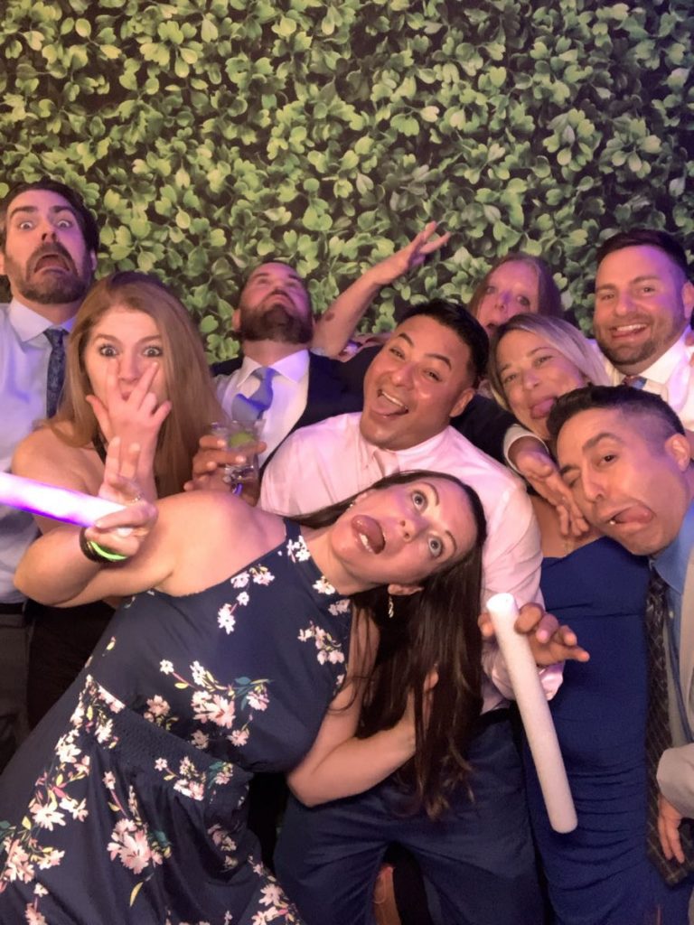 A group of people posing for a picture in front of a wall. A group of people posing for a picture in front of a wall.