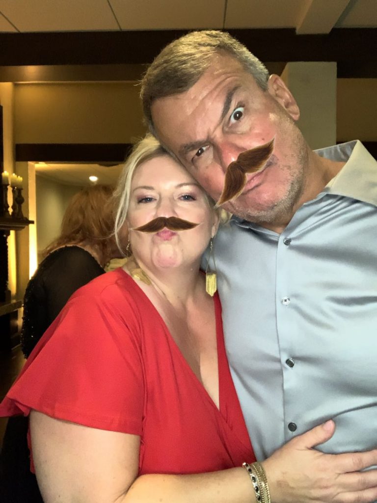 A man and woman with fake mustaches on their faces. A man and woman with fake mustaches on their faces.