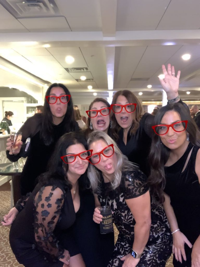 A group of women wearing red glasses and smiling. A group of women wearing red glasses and smiling.