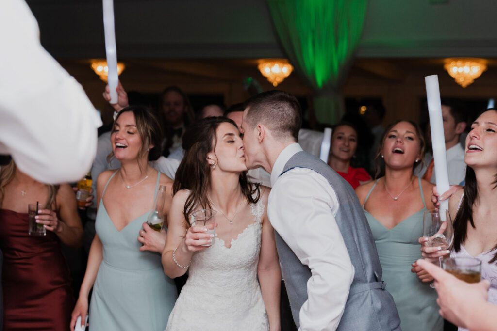 A bride and groom kissing in front of the crowd. A bride and groom kissing in front of the crowd.