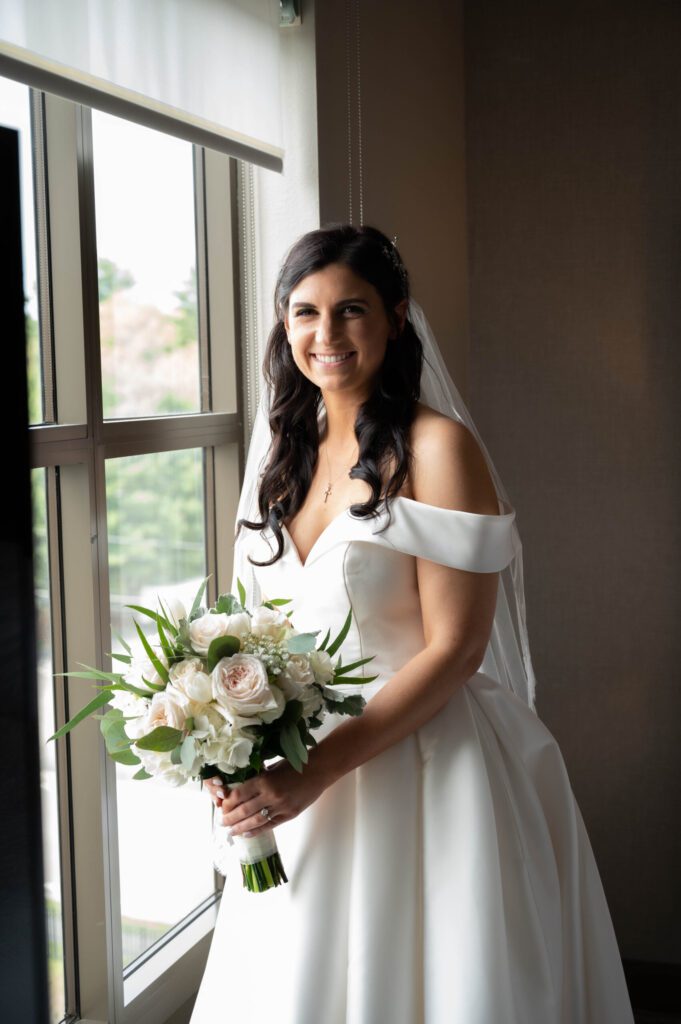 A bride holding her bouquet in front of the window. A bride holding her bouquet in front of the window.
