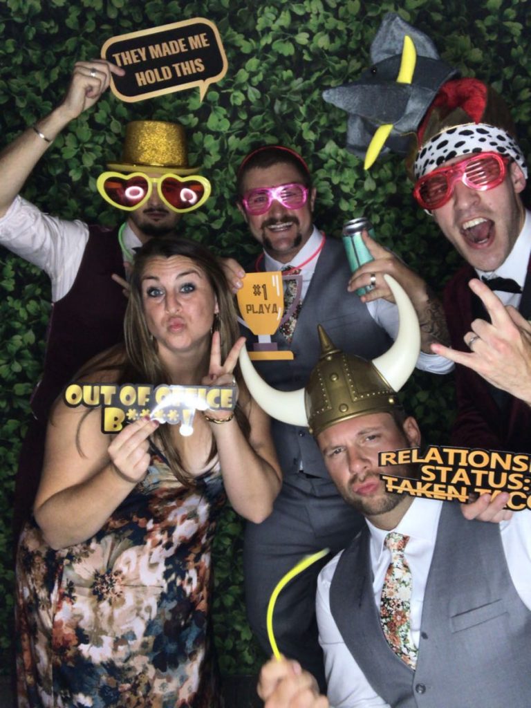 A group of people standing in a photo booth. A group of people standing in a photo booth.