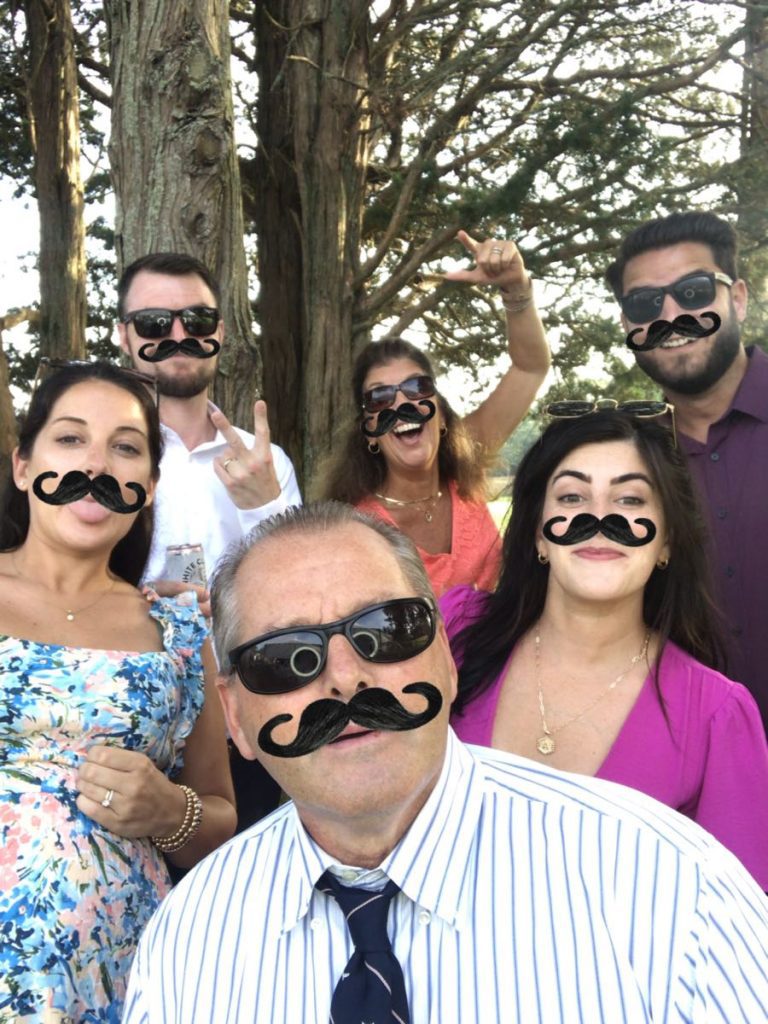 A group of people with fake mustaches on their faces. A group of people with fake mustaches on their faces.