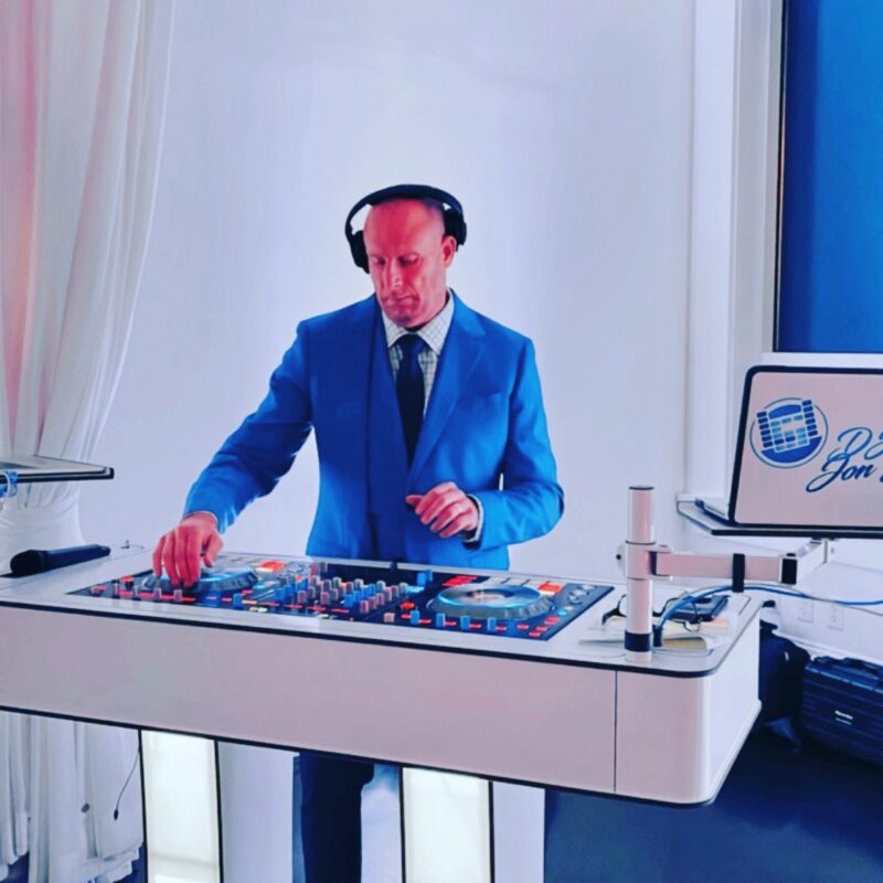 A man in blue jacket and headphones on top of a table.