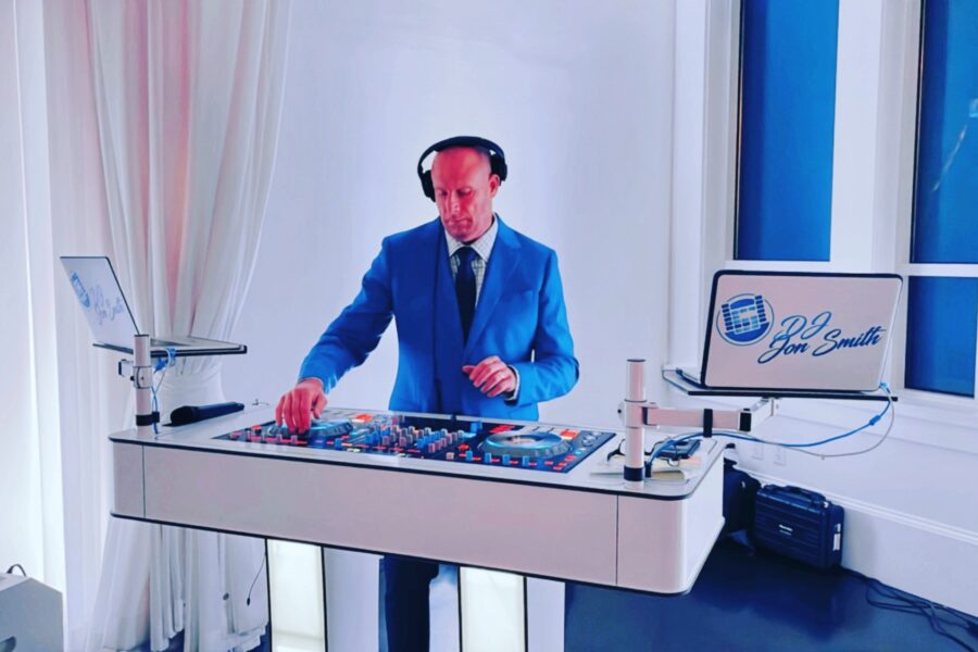 A man in blue jacket and headphones on top of a table.