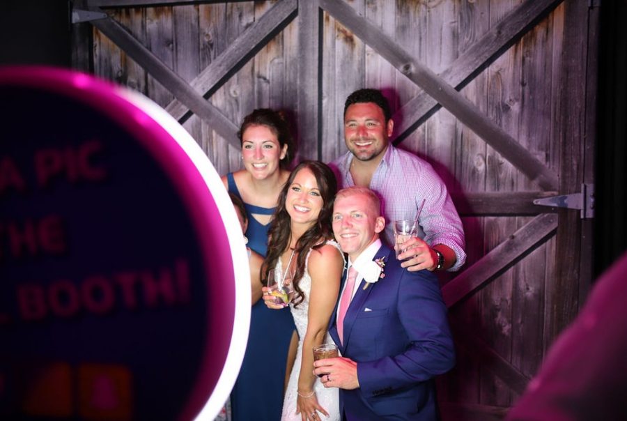 A group of people posing for a photo in front of a mirror.