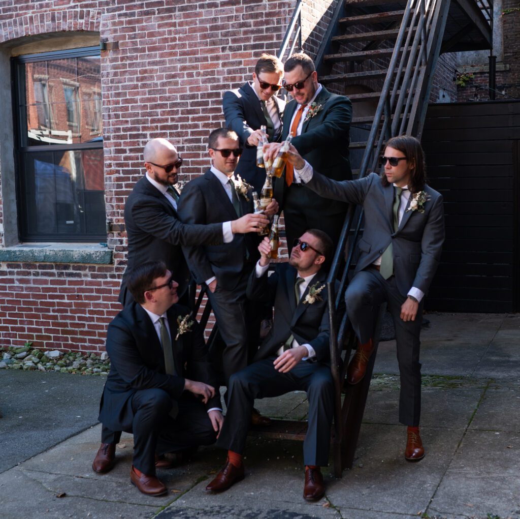 A group of men in suits celebrating with champagne outdoors. A group of men in suits celebrating with champagne outdoors.