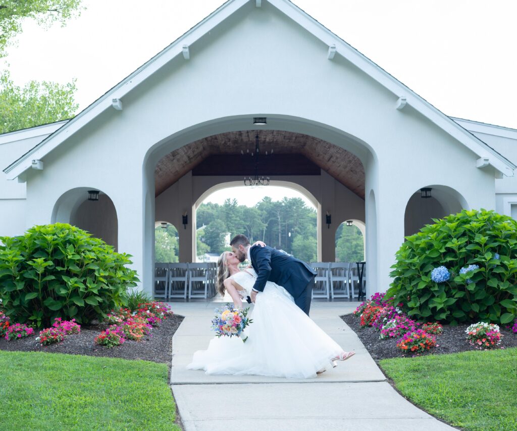 Bride and groom share a kiss under a gazebo after their wedding ceremony. Bride and groom share a kiss under a gazebo after their wedding ceremony.