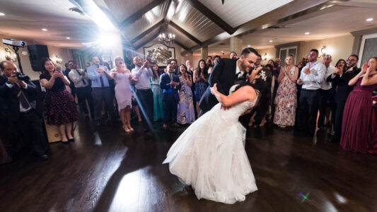 A bride and groom are dancing in front of the crowd.