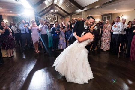 A bride and groom are dancing in front of the crowd.