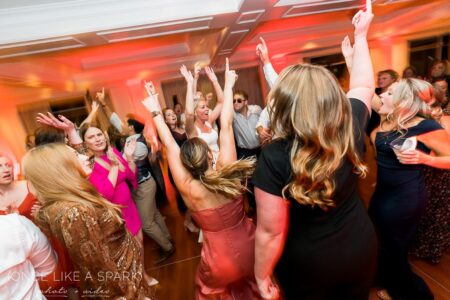 A group of people dancing in the middle of a room.