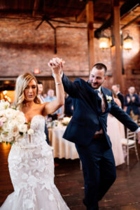 A bride and groom are holding hands as they walk down the aisle.
