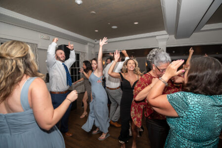 A group of people dancing in the middle of a room.