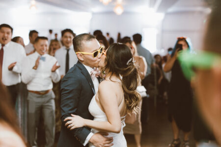 A couple kissing in front of a crowd.