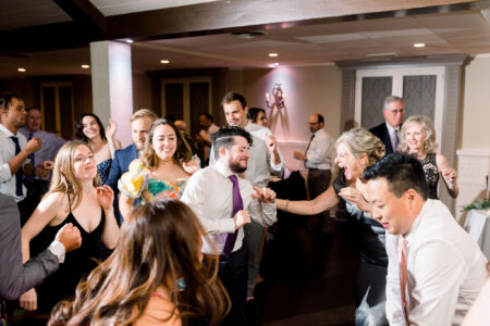 A group of people dancing in the middle of a room.