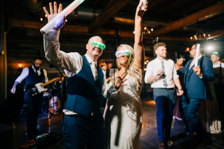 A man and woman are holding up their arms.
