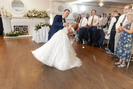 A bride and groom are dancing in front of the crowd.