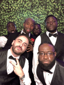 A group of men in suits and bow ties posing for the camera.