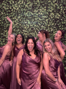 A group of women in purple dresses posing for the camera.