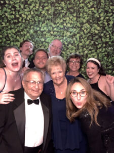 A group of people posing for a picture in front of a wall.