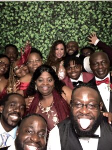 A group of people posing for a picture in front of a wall.