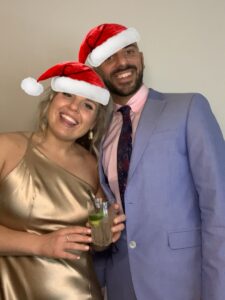 A man and woman wearing santa hats posing for the camera.