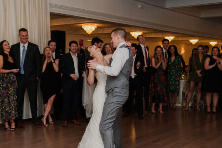 A bride and groom are dancing at their wedding.