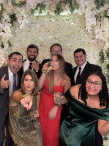 A group of people standing in front of flowers.