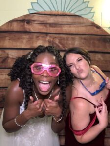 Two women posing for a photo booth picture.