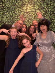 A group of people posing for a picture in front of a wall.