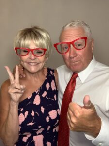 A man and woman wearing red glasses posing for the camera.