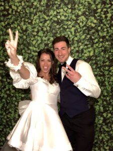 A man and woman posing for a picture in front of a wall.