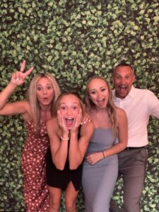 A group of people posing for the camera in front of a wall.
