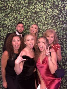 A group of people posing for the camera in front of a wall.