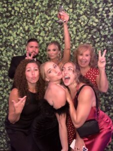 A group of people posing for the camera in front of a wall.