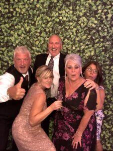 A group of people posing for a picture in front of a wall.