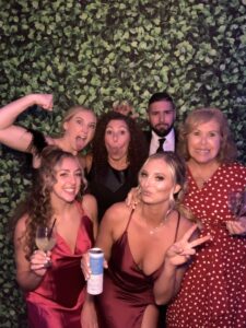 A group of people posing for the camera in front of a wall.
