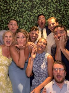 A group of people posing for a picture in front of a wall.