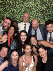 A group of people posing for a picture in front of a wall.