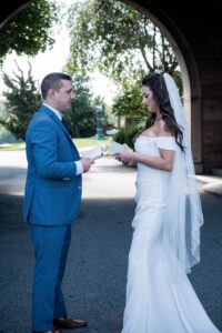Bride and groom exchange vows outdoors during wedding ceremony.