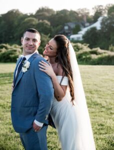 Bride affectionately embracing groom outdoors on their wedding day.