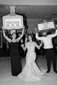 Newlyweds celebrating with signs in a joyful wedding scene.