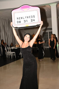 Joyful bride celebrating with a sign at her wedding reception.