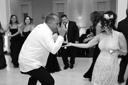 Man and woman dancing energetically at a formal event.