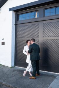 Couple sharing a tender moment near a large wooden door.